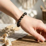 model wearing golden obsidian bracelet for protection and empowerment