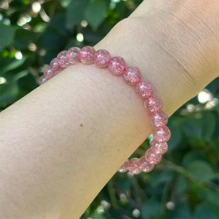 model wearing Strawberry Quartz Bracelet under natural light front view